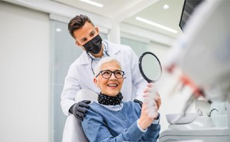 Senior woman smiling at reflection in handheld mirror