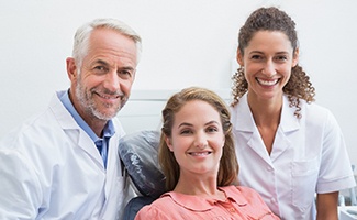 Female patient alongside dentist and dental hygienist