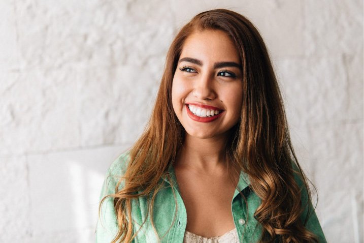 Smiling young woman in light green button up shirt