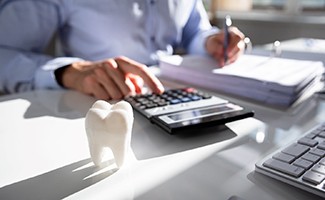 Patient using calculator on desk next to prop tooth